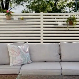 Mysig uteplats med en rumsavdelare av ett vitt staket för att få en ombonad känsla.