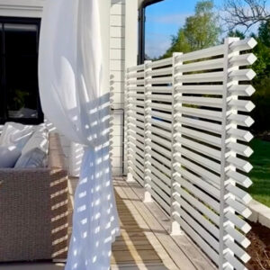 Avskärmnings vägg på uteplatsen av ett vitt staket.